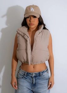 Detail view of khaki stand-collar puffer vest with front zipper and adjustable drawstring hem