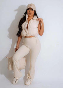Full-body street style view of women's cream quilted vest with high waist flare pants