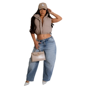 Detailed full-body view of a stylish khaki puffer vest with drawstring waist and denim jeans