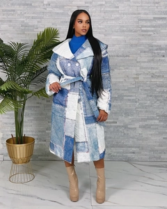 Detail of long denim patchwork coat featuring oversized lapels and matching waist belt