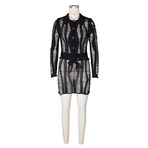 Détails d'une robe en maille ajourée noire avec col boutonné et texture effet usé