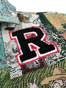 Detailed macro view of woven jacquard fabric with embroidered letter R patch on jacket
