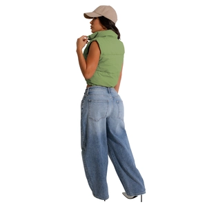Side view of fashionable bean green quilted puffer vest paired with high waist wide leg jeans