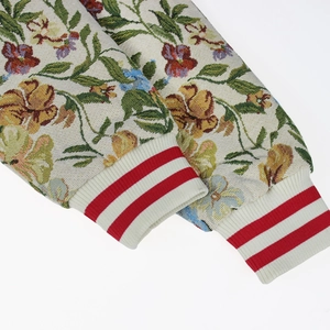 Detail of floral jacquard embroidery with red and white striped ribbed cuffs on a jacket