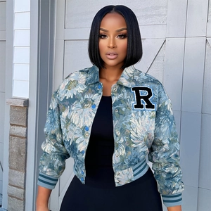 Close-up of vintage floral jacquard texture and varsity letter R patch on the jacket
