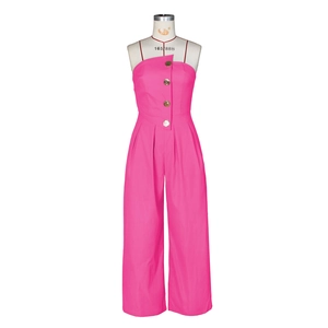 Detail of rose pink strapless jumpsuit featuring large gold buttons and asymmetric fold