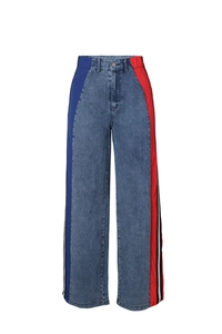 Detail showing high waist patchwork denim pants with side athletic stripes and red nylon panels