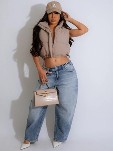 Women's beige stand-up collar sleeveless puffer vest paired with high-waist jeans