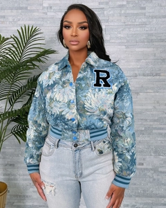 Detail of floral printed baseball jacket with embroidered R letter and ribbed cuffs