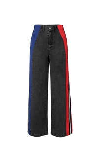 Detail of color block wide leg jeans featuring red and blue side panels and striped trim