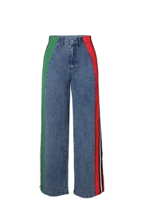 Detail of high waisted straight jeans featuring red and green side stripes and denim texture