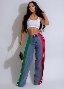 Detail of high-waist jeans featuring vibrant red and green side stripes and loose fit