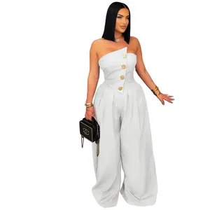 Detailed view of large gold textured metal buttons on a white strapless wide-leg jumpsuit