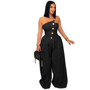 Detail of black strapless jumpsuit with asymmetric cut and golden vintage buttons