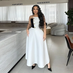 Detail of elegant two-piece set featuring gold embossed buttons on a contrast bodice