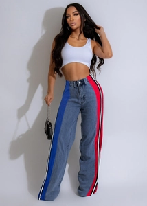 Detail shot of high-waisted wide-leg jeans with striking side stripes in blue and red