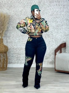 Detail of floral bomber jacket with R patch and matching ripped jeans with floral inserts