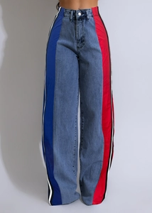 Detail of high-waisted wide-leg jeans featuring side color-block stripes in red and blue