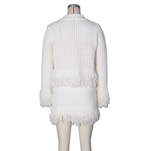 Detailed back view of white knit cardigan and skirt set featuring long fringe trim details