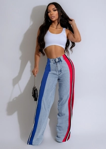 Detail of color-block striped denim trousers with blue and red side panel contrast
