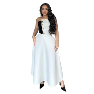 Close-up of golden decorative buttons on black and white strapless two-piece dress