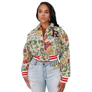 Detail of floral tapestry jacket with vintage letter R patch and striped ribbed cuffs