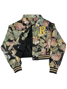 Detailed view of vintage floral jacquard fabric with embroidered R patch on varsity jacket