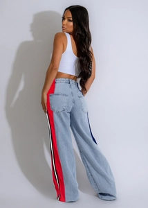Detail of side stripe patchwork on light wash denim wide-leg jeans with racer style trim
