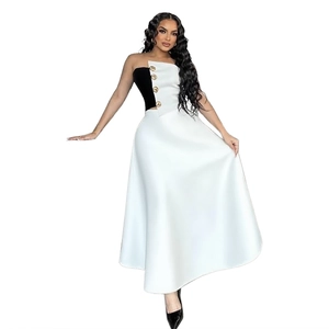 Detail of elegant black tube top with gold buttons and a white A-line maxi skirt