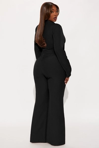 Detail of black ribbed knit wide-leg jumpsuit with long sleeves and bow tie waist design