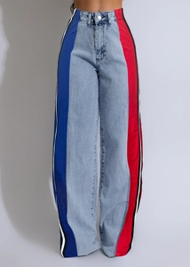 Detail of high waist jeans with contrast red and blue patchwork and side stripes