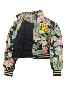 Detailed macro of vintage floral jacquard fabric and yellow R patch on baseball jacket