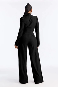 Rear view of a black ribbed wide-leg jumpsuit showing elegant tie-waist and slim fit design