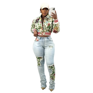 Detail of floral print cropped bomber jacket and ripped jeans with matching fabric patch