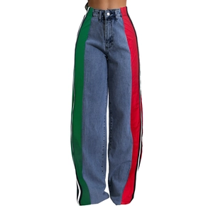 Detail of high-waisted jeans featuring blue denim with green and red side patchwork panels