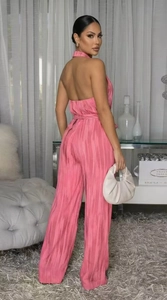 Detail of pink pleated halter jumpsuit showing open back and elegant texture fabric
