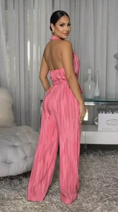 Detail view of pink pleated halter jumpsuit showing open back and tie-waist features