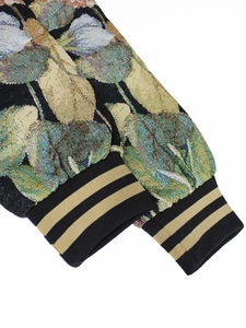 Detail of vintage floral jacquard fabric and striped ribbed cuffs on the jacket