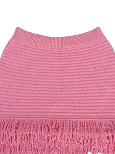 Close-up of pink knit mini skirt featuring elegant horizontal wave texture and long fringes