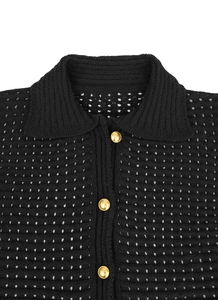 Detail view of a black crochet polo collar with three vintage gold buttons and mesh knit texture
