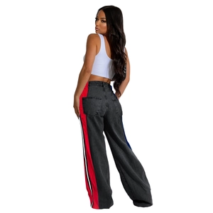Detail view of high-waisted dark grey wide-leg jeans with red and white side stripe trim