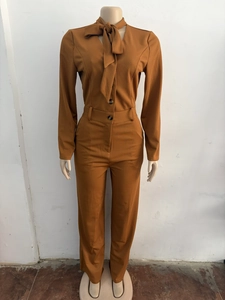 Detail of ribbed knit texture on caramel brown jumpsuit with elegant bow tie neckline