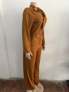Detail view of caramel brown ribbed jumpsuit with stylish bow tie neck and wide leg fit