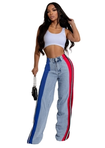 Detail of high-waist patchwork jeans featuring red, blue, and black striped side panels