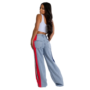 Detail view of high-waisted wide-leg denim jeans with athletic side stripes and back pockets
