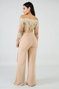 Detail of elegant beige off-shoulder jumpsuit with gold floral lace embroidery