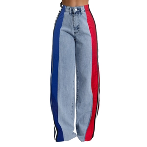 Detail of high-waisted denim pants with blue and red side panels and athletic side stripes