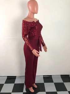 Detail view of burgundy off-shoulder jumpsuit featuring lace sleeves and tie-waist