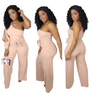 Detail of pink one-shoulder wide-leg jumpsuit with a waist bow tie and hollow sleeve
