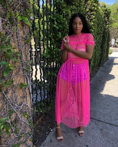 Detail view of pink sheer mesh dress showing ruffled layers and puff sleeve texture